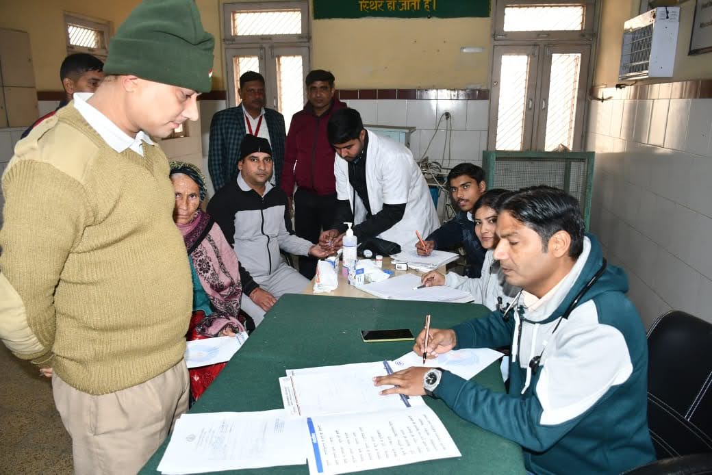 Dr. Riaz Ahmad examining patient and writing treatment plan at rural camp